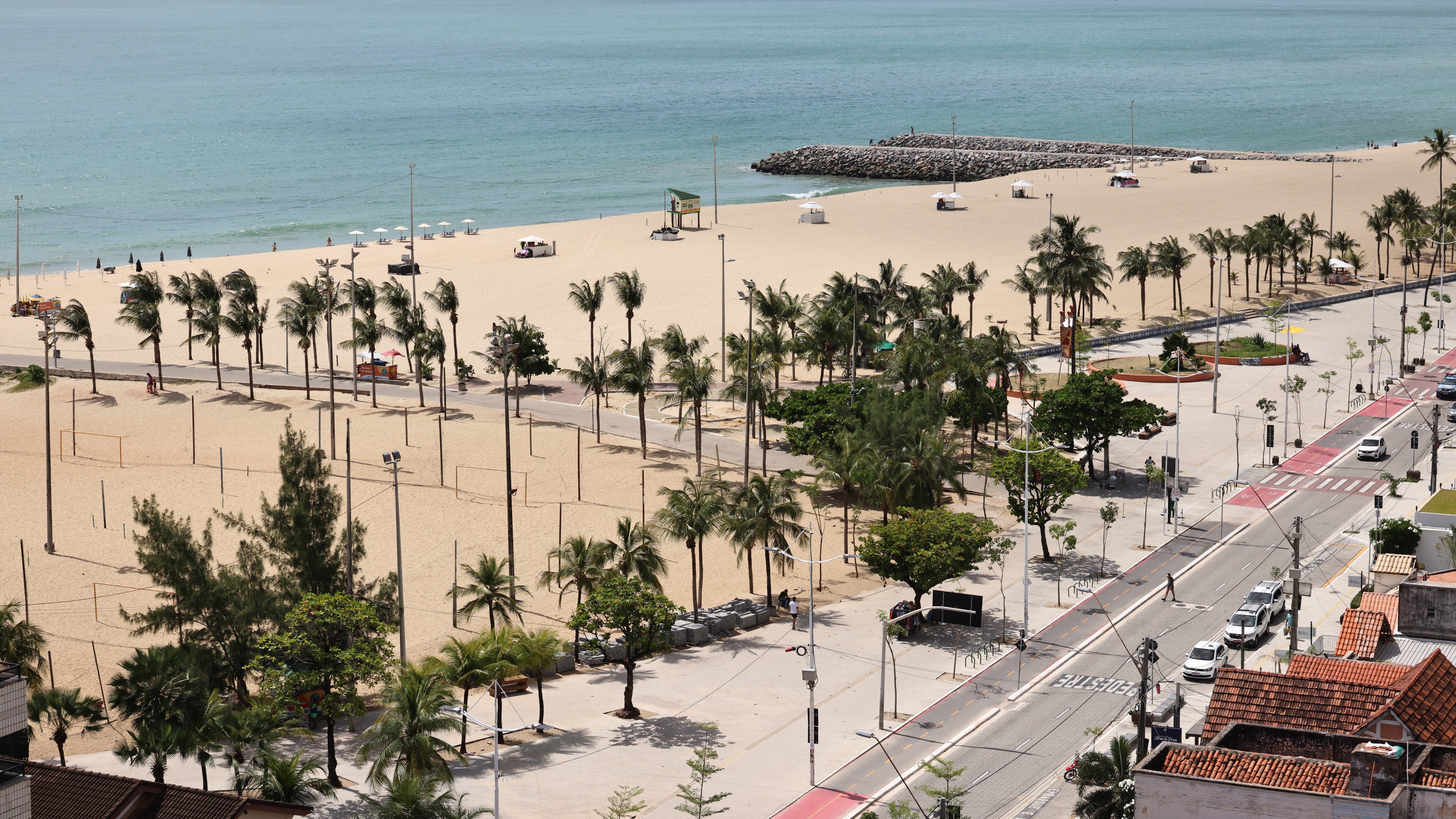foto panorâmica do calçadão da beira-mar, mostrando também a faixa de areia e o mar